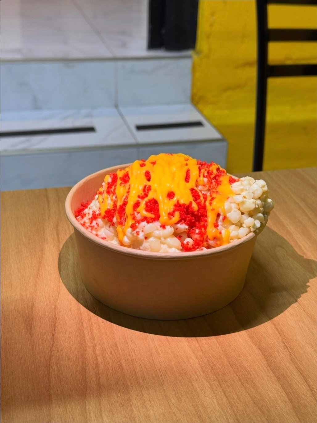 Vaso preparado con elote, Sabritas trituradas y queso amarillo